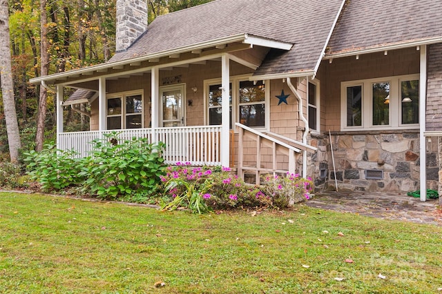 entrance to property with a yard and a porch