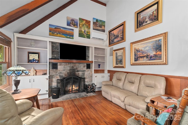 living room featuring hardwood / wood-style flooring, beam ceiling, high vaulted ceiling, a fireplace, and built in shelves