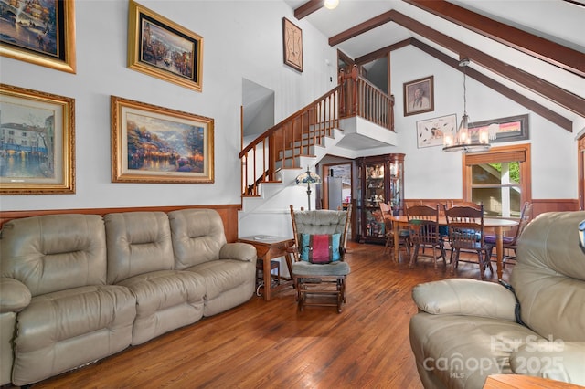 living room with an inviting chandelier, hardwood / wood-style floors, beam ceiling, and high vaulted ceiling