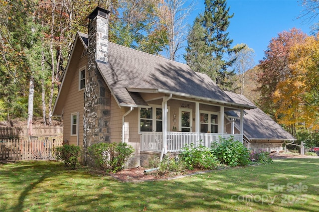 view of side of home featuring a yard and covered porch