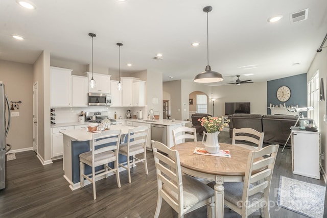 dining area featuring ceiling fan, sink, and dark hardwood / wood-style flooring