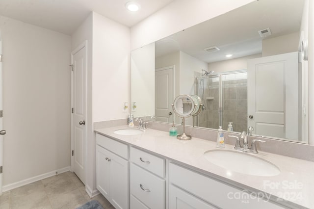 bathroom featuring tile patterned flooring, vanity, and a shower with shower door