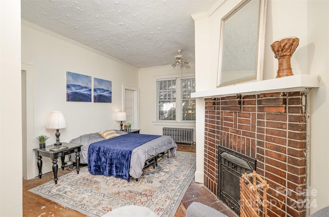 bedroom featuring radiator, ceiling fan, a textured ceiling, and a brick fireplace