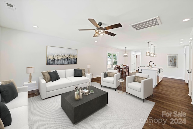 living room with sink, dark wood-type flooring, and ceiling fan