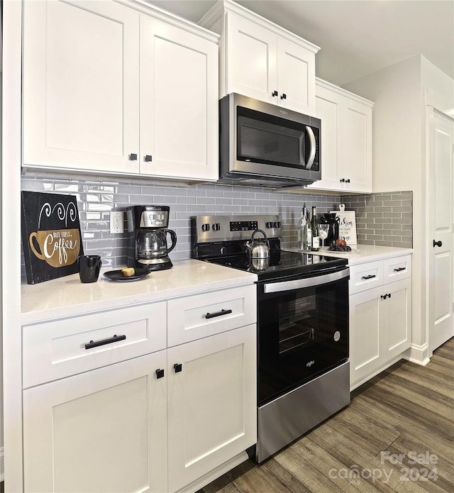 kitchen with white cabinetry, backsplash, stainless steel appliances, and dark wood-type flooring