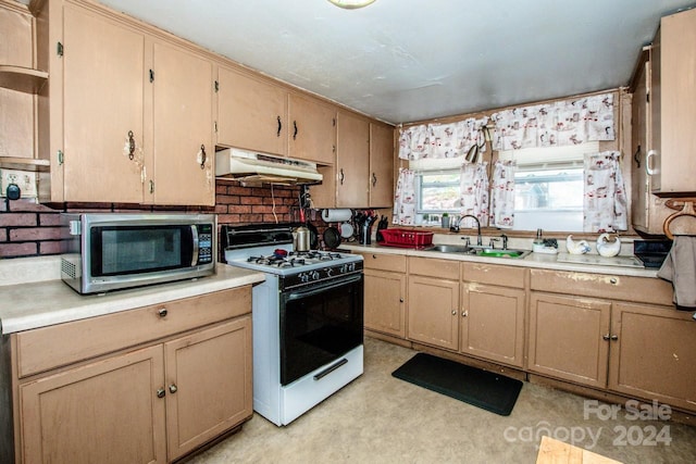 kitchen with light brown cabinets, white gas range, ventilation hood, and sink