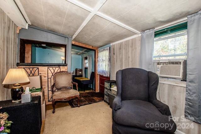 sitting room with wood walls, carpet, and cooling unit