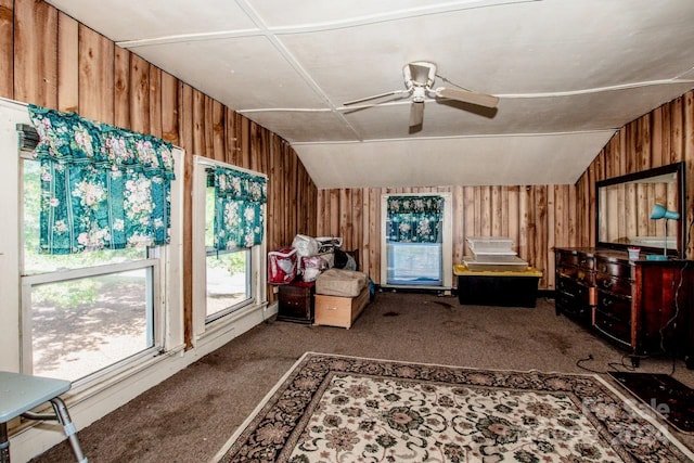 miscellaneous room with lofted ceiling, wood walls, and carpet