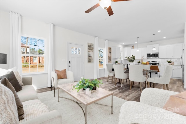 living room featuring ceiling fan and light hardwood / wood-style flooring