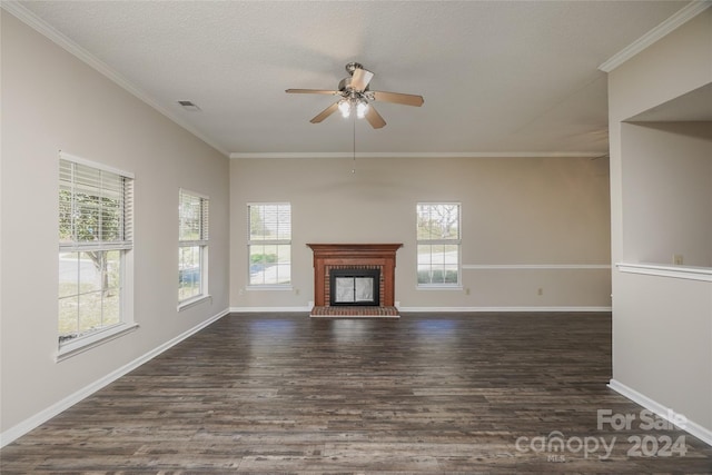 unfurnished living room with dark wood-type flooring, a brick fireplace, a wealth of natural light, and ceiling fan