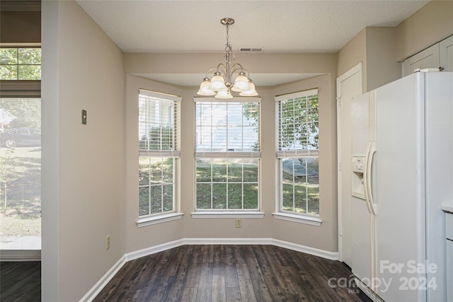 unfurnished dining area featuring a notable chandelier and dark hardwood / wood-style flooring