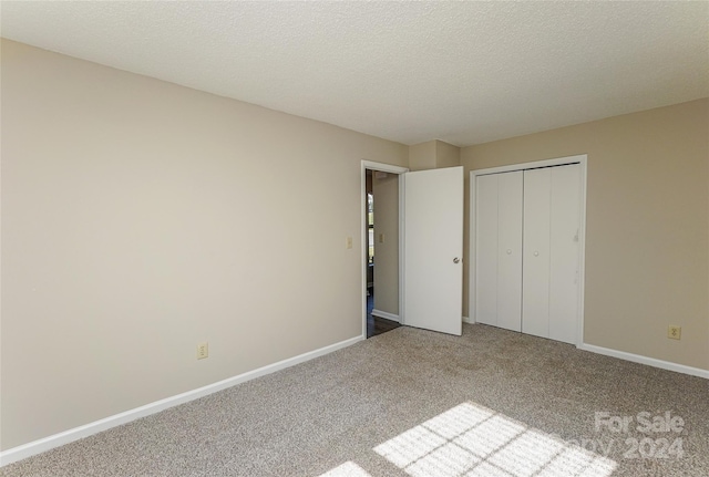 unfurnished bedroom with carpet floors, a closet, and a textured ceiling