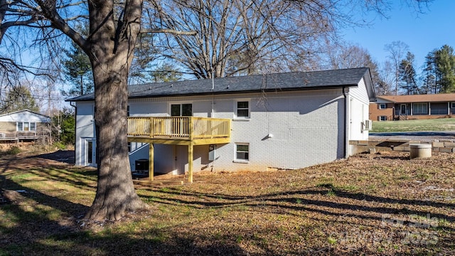 rear view of property featuring a wooden deck and a yard