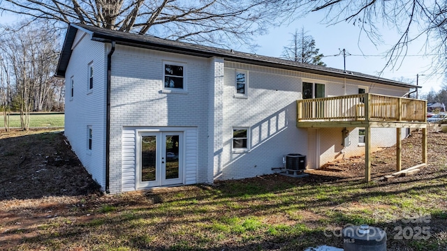 back of house with a wooden deck, a yard, central air condition unit, and french doors