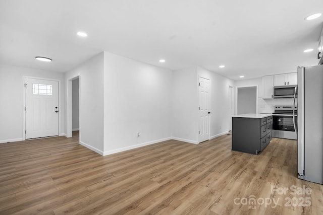 kitchen featuring gray cabinetry, tasteful backsplash, a kitchen island, stainless steel appliances, and white cabinets