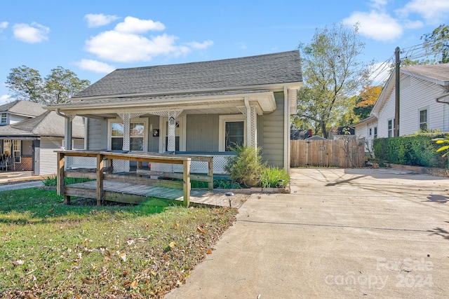 bungalow-style house with a front lawn and covered porch