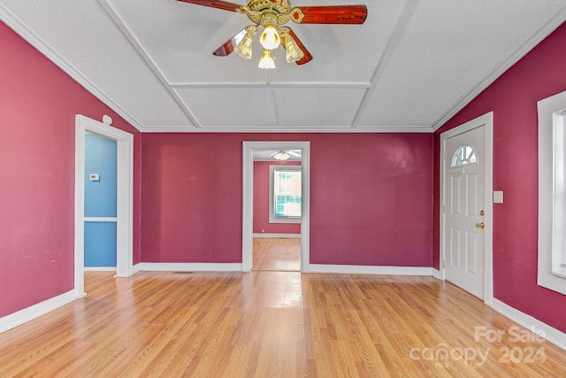 entrance foyer featuring a textured ceiling, ceiling fan, ornamental molding, and light hardwood / wood-style flooring