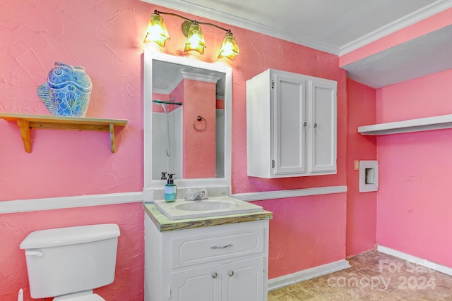 bathroom with ornamental molding, vanity, and toilet