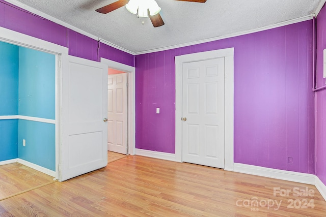 unfurnished bedroom featuring wood-type flooring, crown molding, and ceiling fan