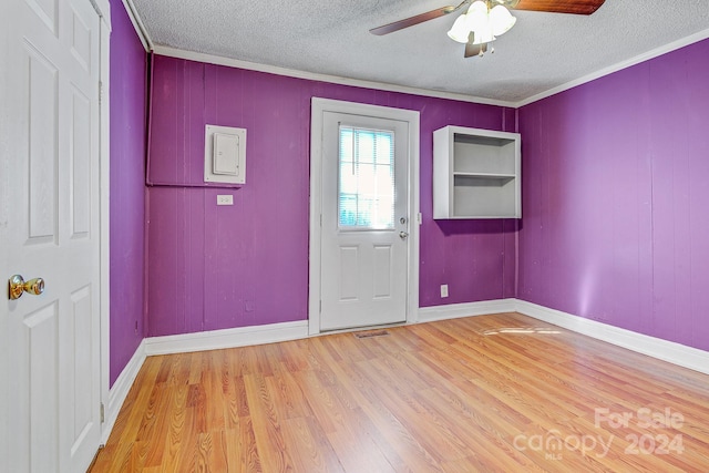 entrance foyer with wood-type flooring, a textured ceiling, crown molding, and ceiling fan