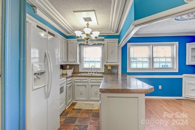 kitchen featuring white appliances, sink, an inviting chandelier, ornamental molding, and decorative light fixtures