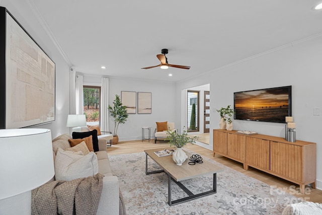 living room featuring ornamental molding, ceiling fan, and light hardwood / wood-style flooring