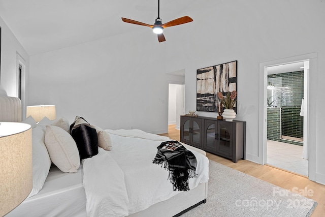 bedroom featuring ceiling fan, connected bathroom, hardwood / wood-style floors, and lofted ceiling