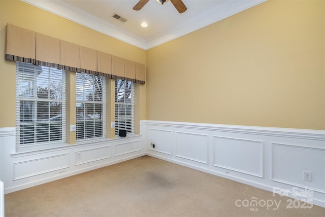 unfurnished room featuring a wealth of natural light, light colored carpet, visible vents, ornamental molding, and ceiling fan