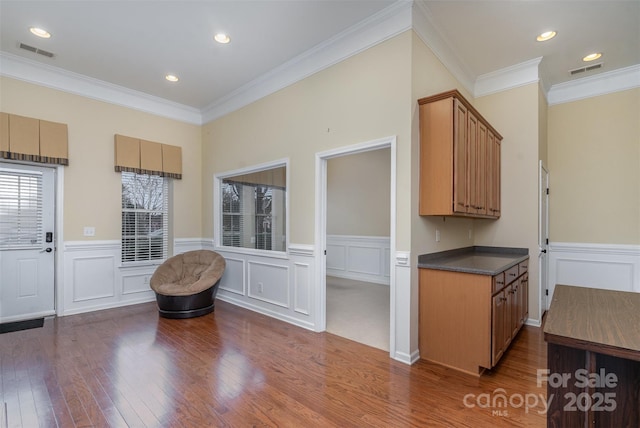 kitchen featuring dark wood-style flooring, dark countertops, visible vents, and brown cabinets