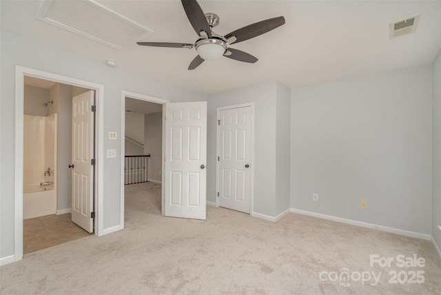 unfurnished bedroom featuring attic access, visible vents, baseboards, and light colored carpet