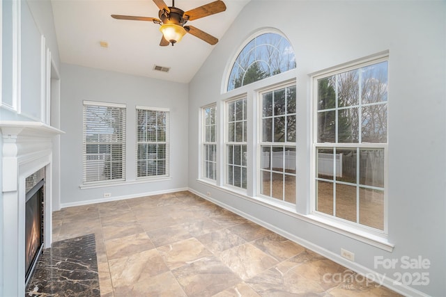 unfurnished sunroom with a fireplace with flush hearth, lofted ceiling, visible vents, and a ceiling fan