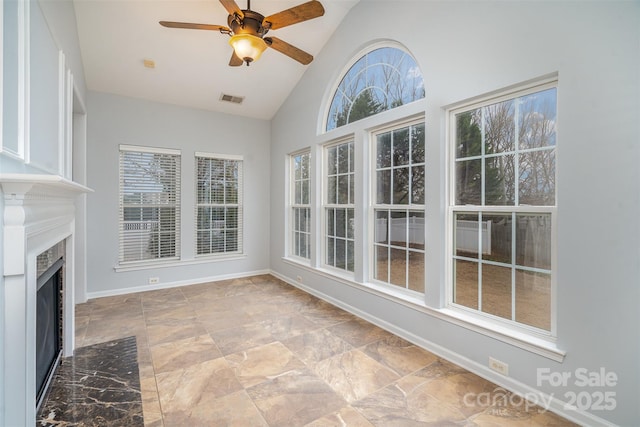 unfurnished sunroom featuring a fireplace with flush hearth, visible vents, vaulted ceiling, and ceiling fan