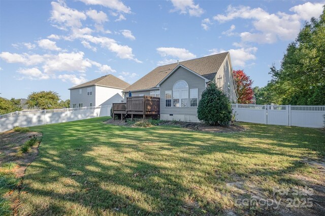 back of house with crawl space, a fenced backyard, and a yard