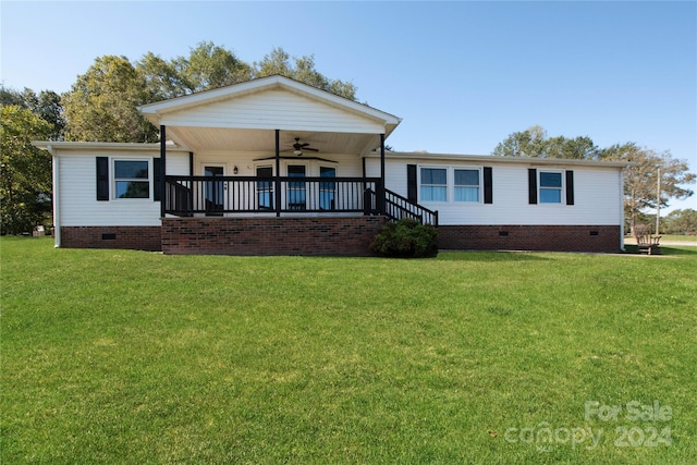 back of house featuring ceiling fan and a yard