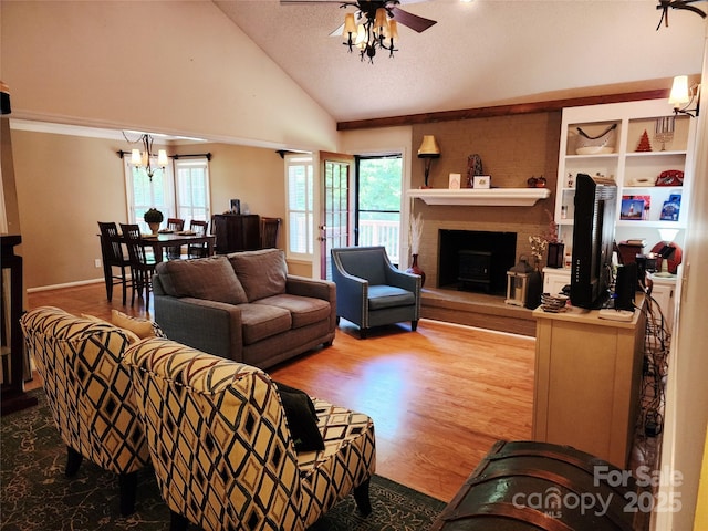2015 Pine Needle Ct, Gastonia, NC 28056 - living area with a ceiling fan, a chandelier, a brick fireplace, wood finished floors, and high vaulted ceiling
