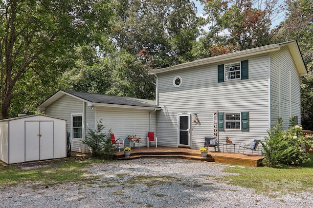 rear view of property featuring a storage shed and a deck