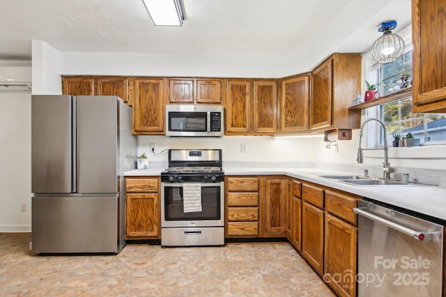 kitchen with decorative light fixtures, sink, and stainless steel appliances