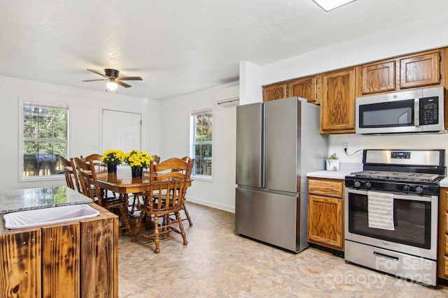 kitchen with a textured ceiling, ceiling fan, stainless steel appliances, and a wall mounted AC