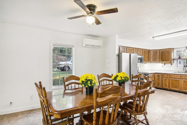 dining space with an AC wall unit, ceiling fan, and sink