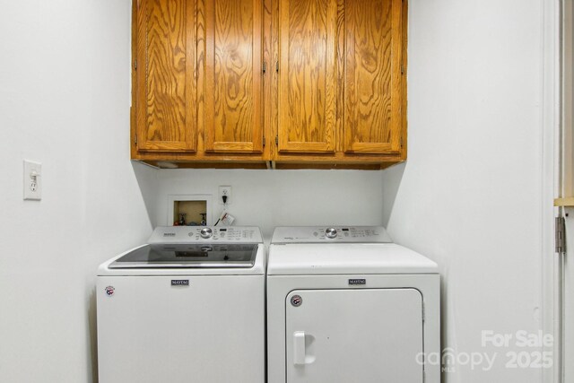 laundry room featuring washer and dryer and cabinets