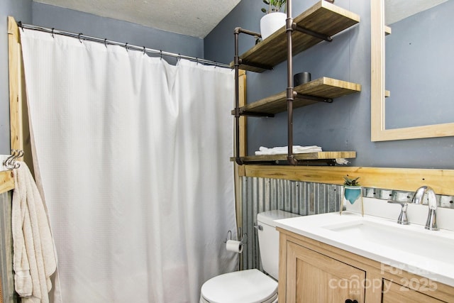 bathroom with vanity, a textured ceiling, and toilet