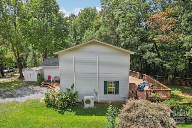 view of home's exterior featuring ac unit, a yard, a shed, and a wooden deck