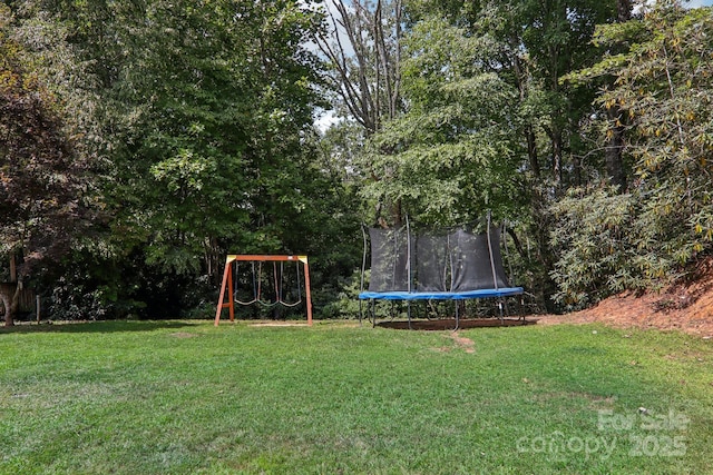 view of yard featuring a playground and a trampoline