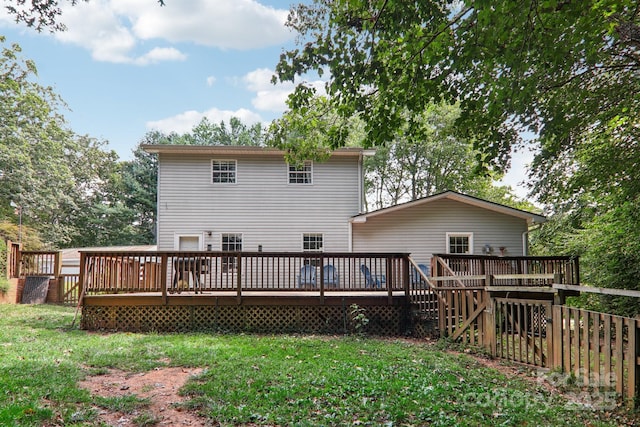 back of house featuring a lawn and a wooden deck