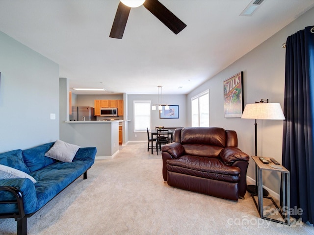 living room with light colored carpet and ceiling fan