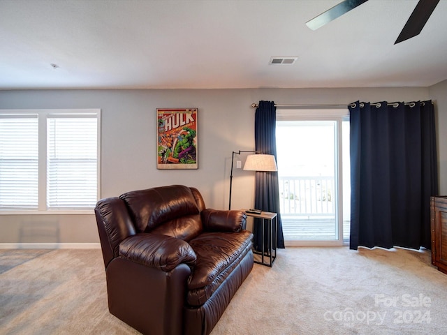 living room with light colored carpet and ceiling fan