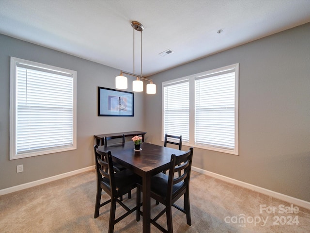 dining space featuring plenty of natural light and light colored carpet