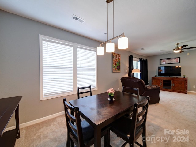 dining room with light carpet and ceiling fan