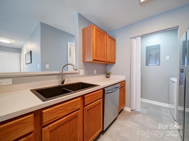 kitchen featuring electric panel, light tile patterned floors, washer and dryer, stainless steel dishwasher, and sink