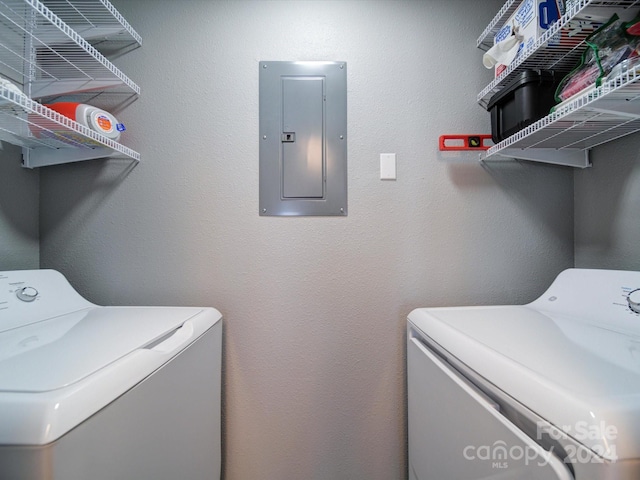 clothes washing area with washer and dryer and electric panel